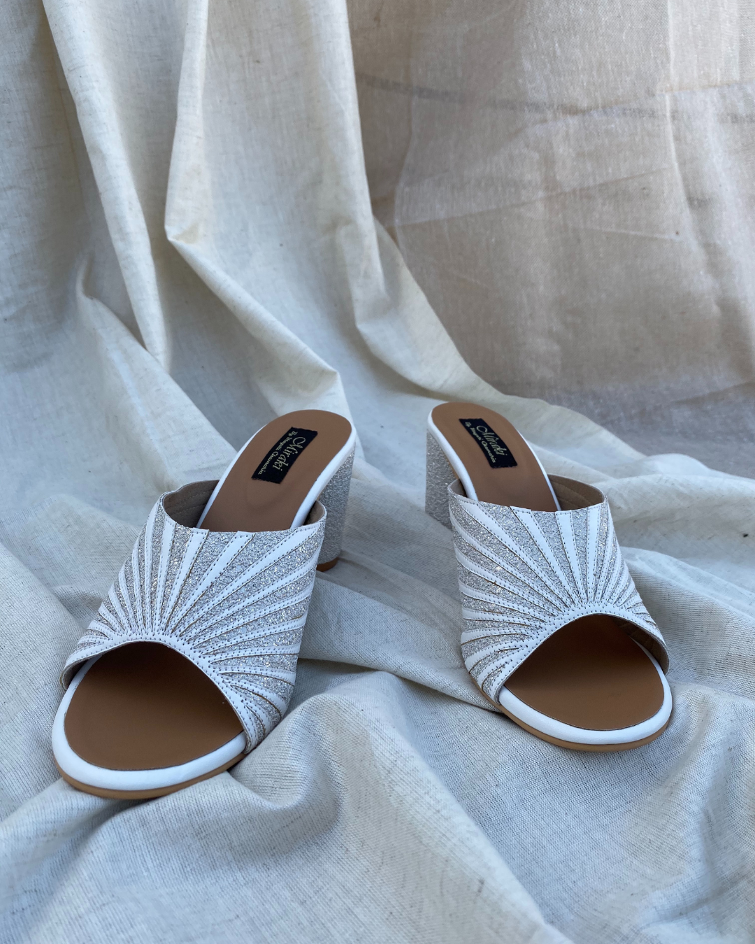 White Pattern Cut Slip Ons With Rounded Heels